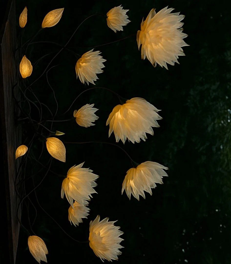 Esculturas de exterior: flores de luz entre el follaje, de noche