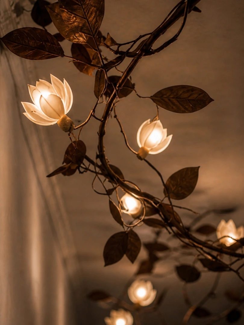 Climbing Magnolia, rama trepadora de hojas metálicas con flores de luz